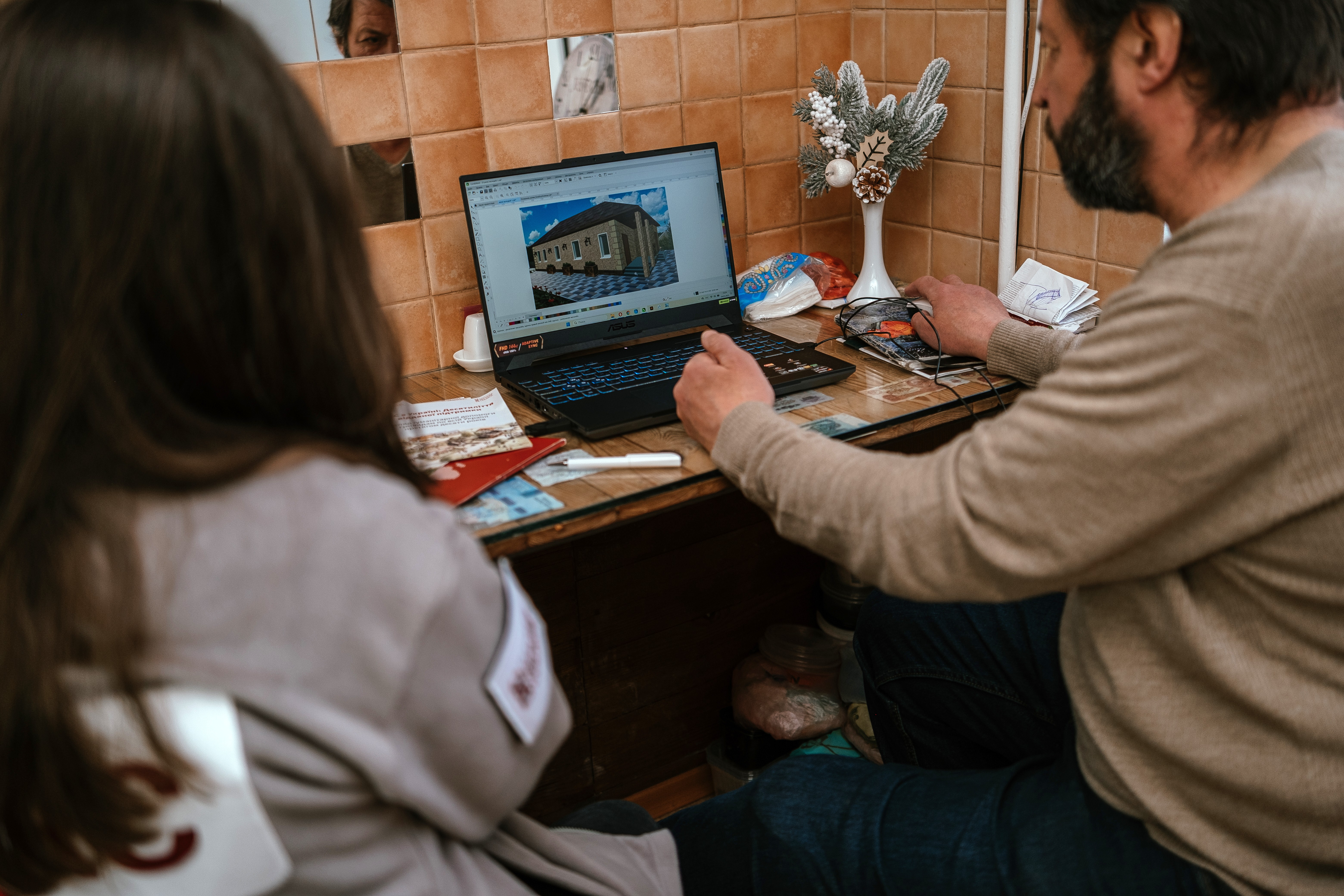 Grigoriy shows a model of a house he created with the help of a new laptop purchased with the German Federal Foreign Office support. ©DRC Ukraine, Kharkiv, Kharkiv Oblast, March 2025, Krystyna Pashkina